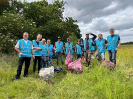 Club members on a sunny day on the banks of the River Brain with plastic bags full of rubbish